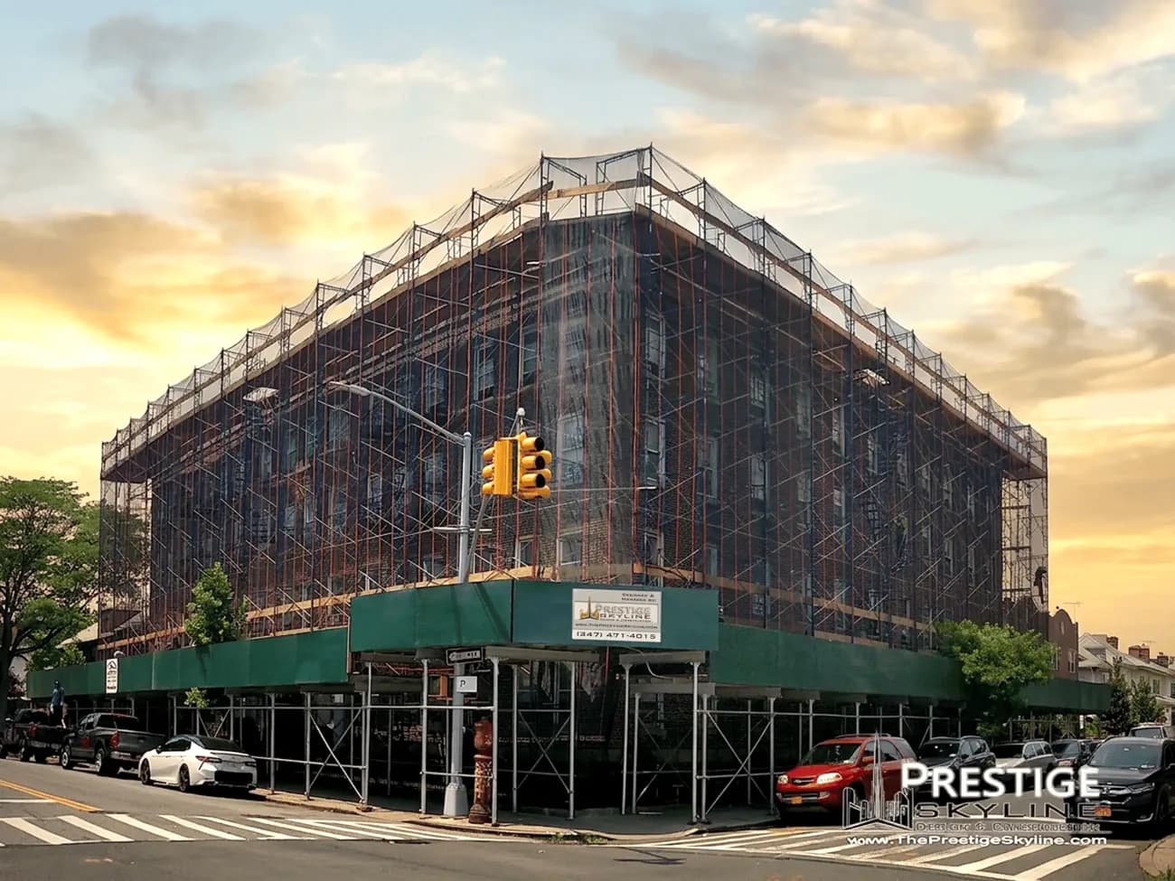 NYC apartment building under full scaffolding during a Prestige Skyline façade renovation at sunset